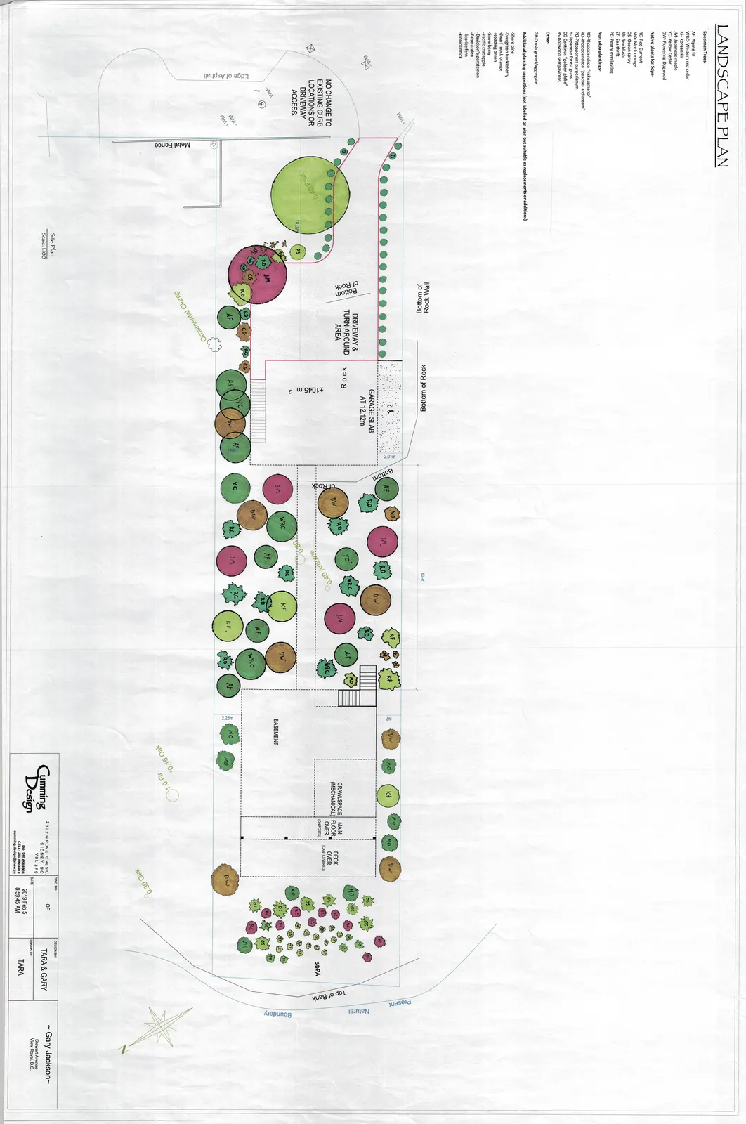 Detailed landscape plan for the property of Tara & Gary Jackson in View Royal, B.C. The plan shows the layout of the property including a driveway, turnaround area, garage slab, house footprint (basement, crawlspace, and deck), and numerous coded plantings throughout the lot extending to a natural boundary at the rear.