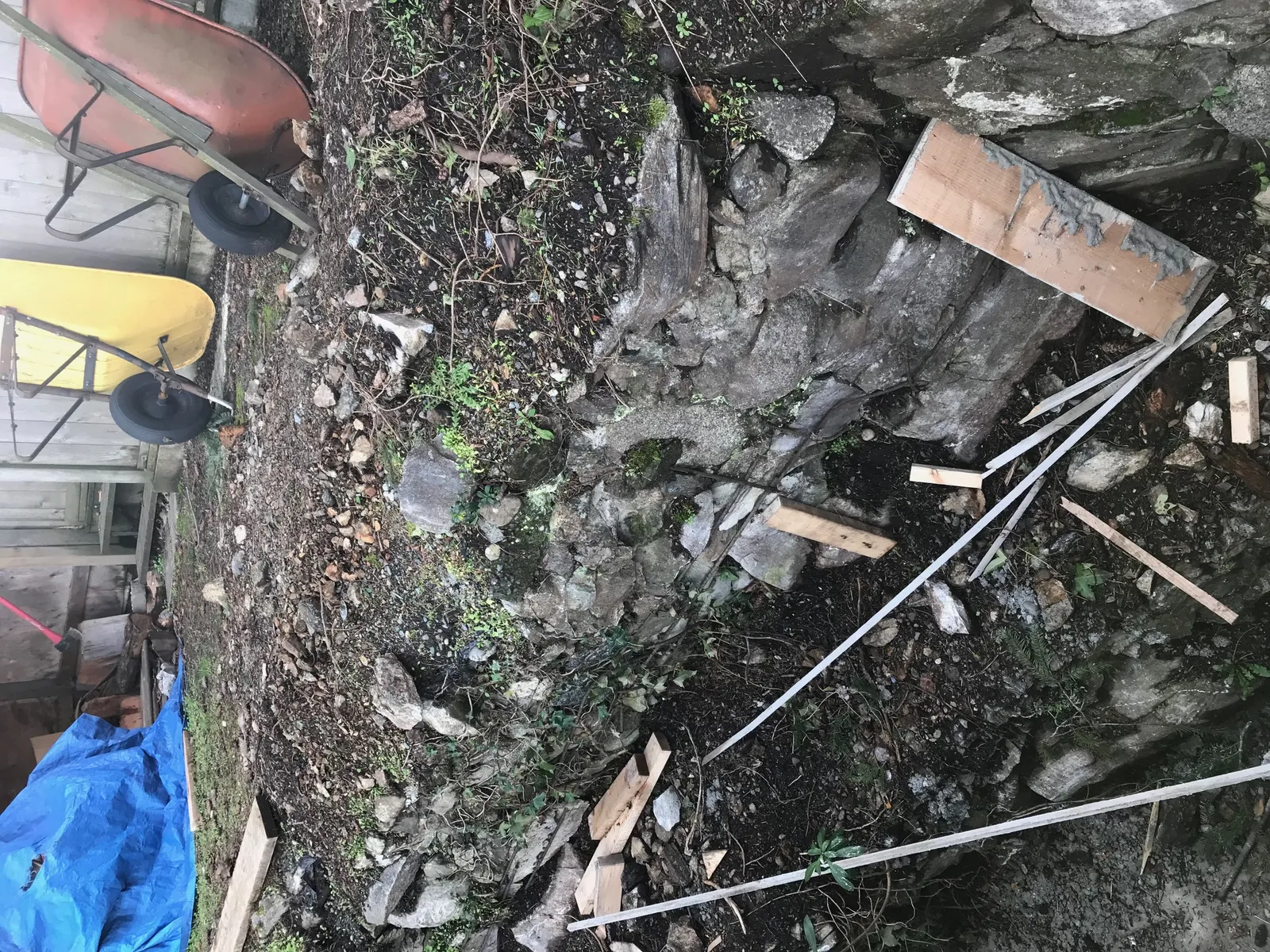 Close-up of an old stone masonry wall and construction debris in the work area.