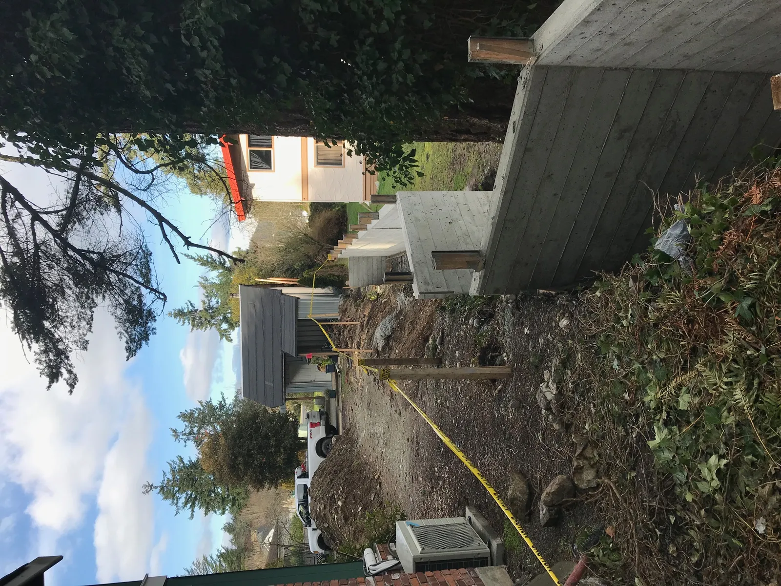 Long view of the tiered concrete wall installation with yellow caution tape marking the work area.