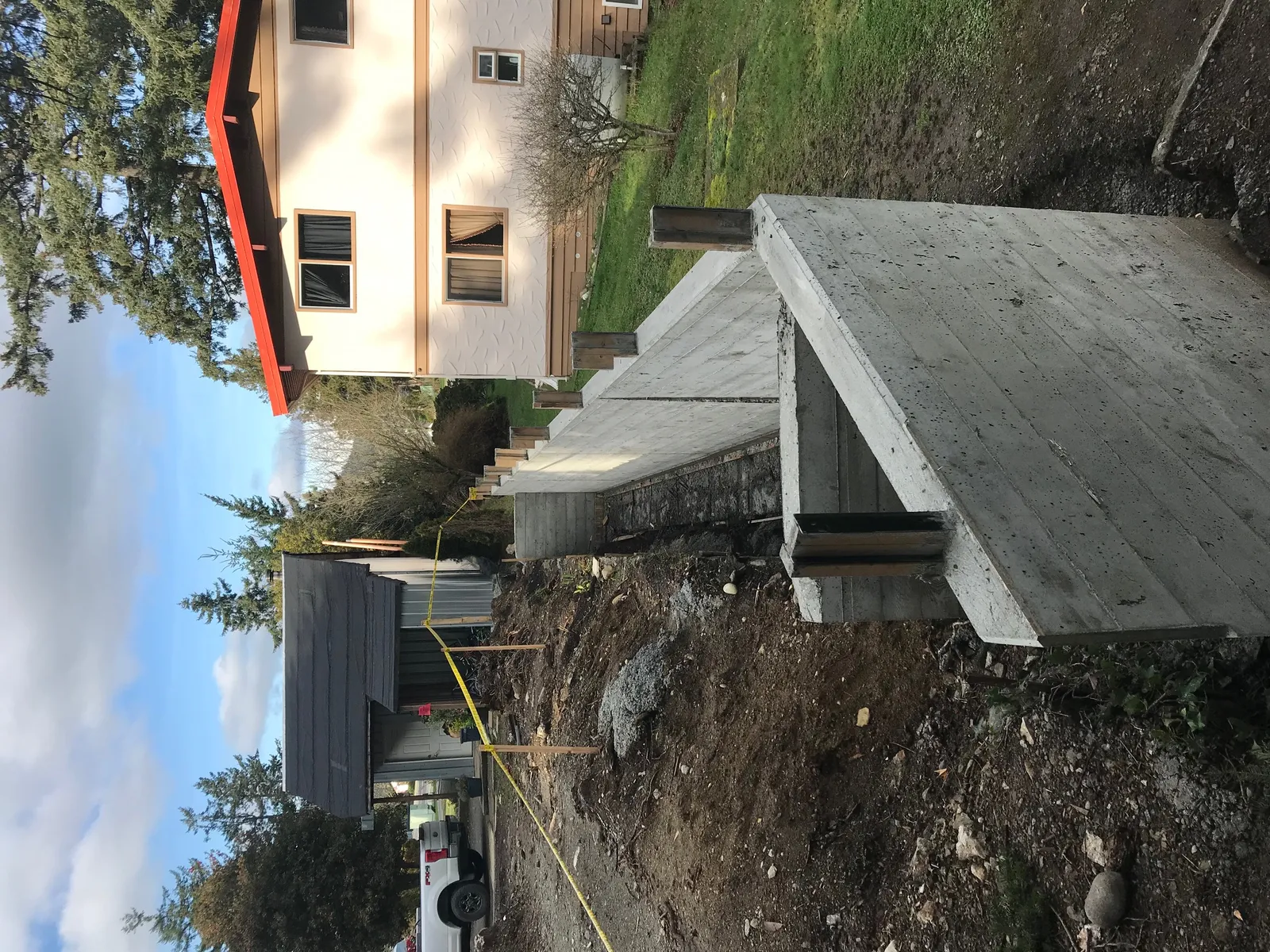 Perspective view of the concrete wall sections showing the excavation and neighboring properties.