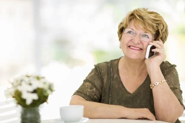A woman smiling while talking on a cellphone