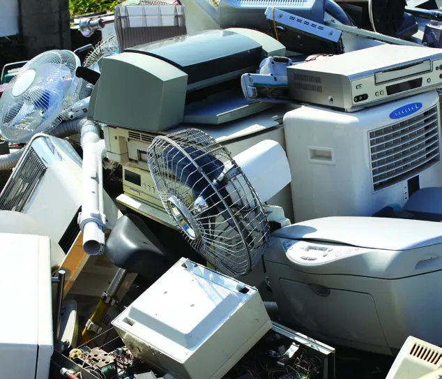 A pile of electronic waste including old computer monitors and fans.