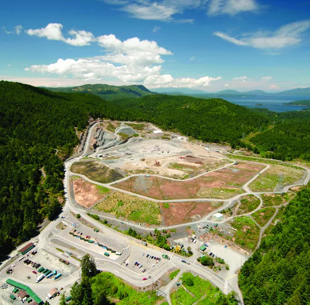 An aerial view of a large landfill facility situated in a wooded area.