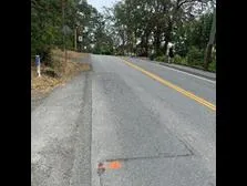 Photo of road showing a section of new asphalt patch and pave