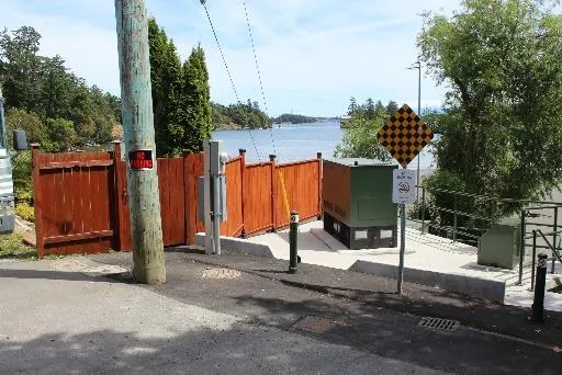 View of Price Bay PS from Price Road showing bollards, new curb stop, new water control and new generator on upper tier