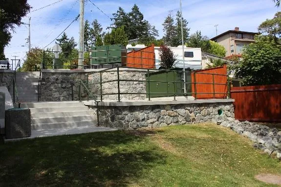 View looking back at Price Bay PS from the beach showing the new rock mortar retaining walls, new railings, new concrete stairs, new rip rap drain channel and new cedar fence