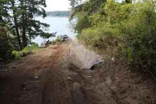 Lining the existing drain swale with approved Geotextile fabric before installing rip rap rock