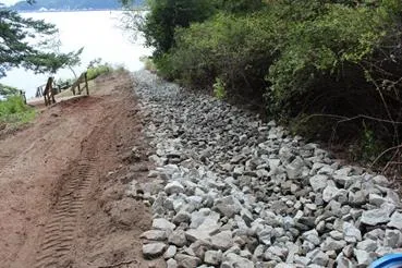 Lining the existing drain swale with approved Geotextile fabric before installing rip rap rock