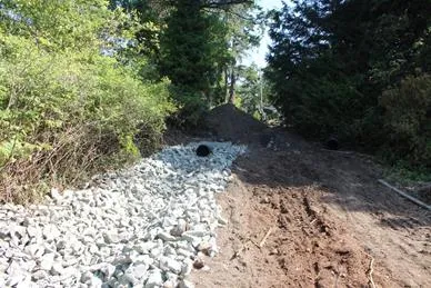 Rip rap rock installed over Geotextile fabric prior to swale formation