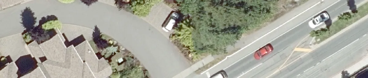 Aerial detail of a curved residential road with parked vehicles