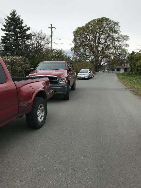 Photo depicting a white car parked on a road shoulder