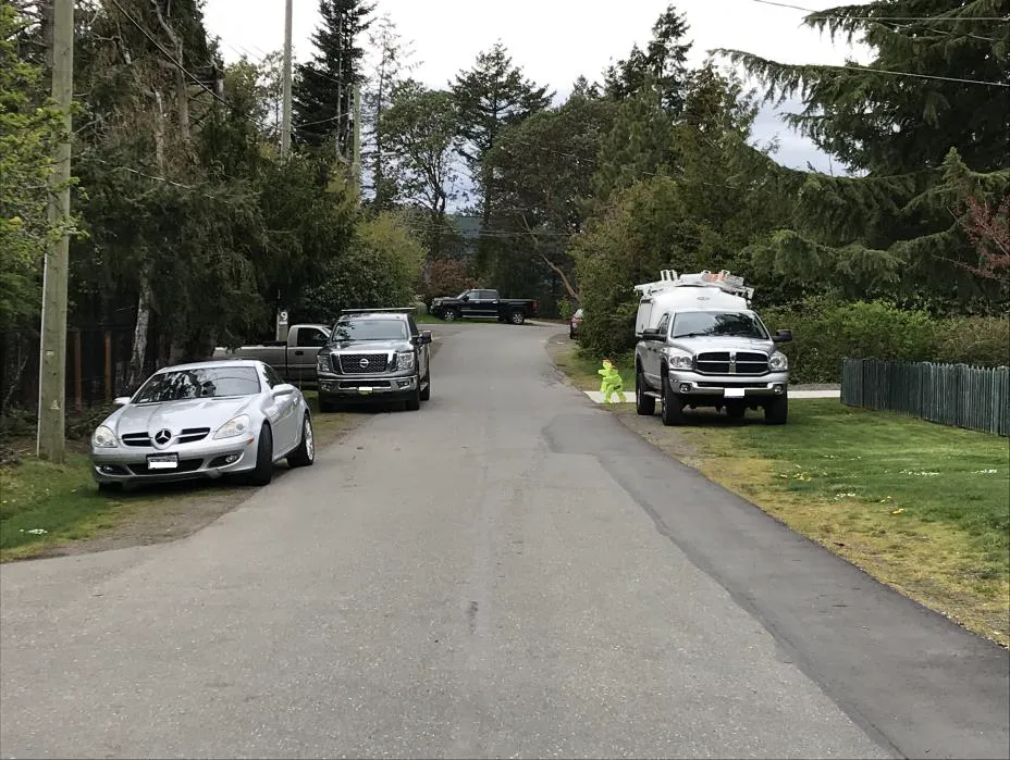 Photo depicting a car and an unattached trailer parked on a road shoulder