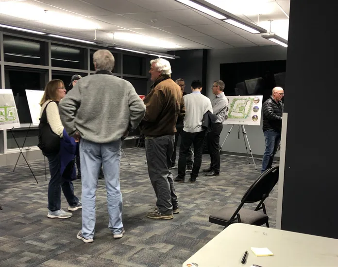Photo showing the "Proposed Revised Site Plan and Development Statistics" board displayed at the meeting.