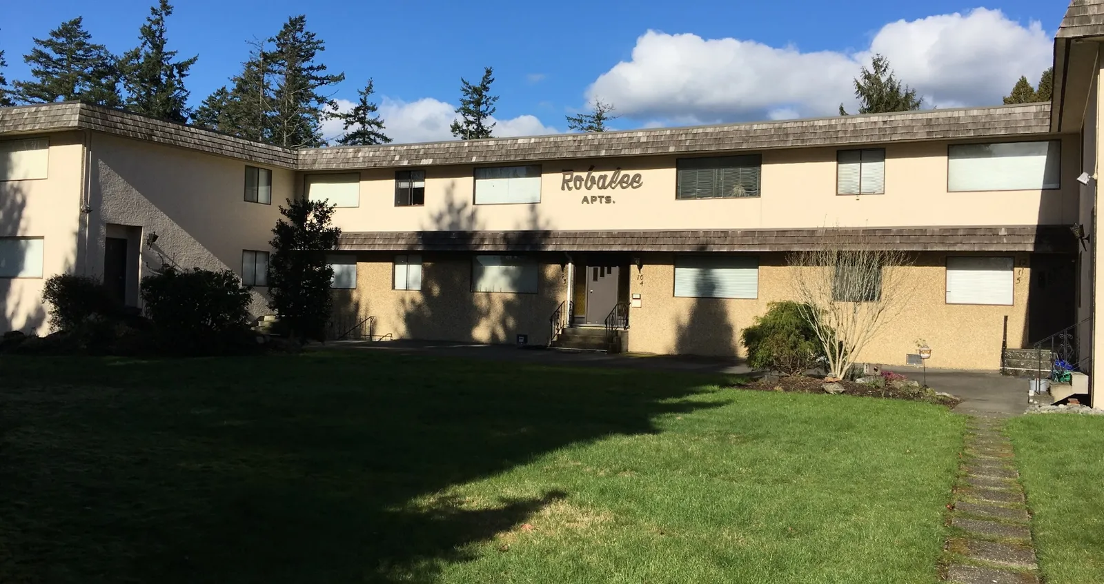 Exterior view of the Robalee APTS. apartment building and surrounding grounds