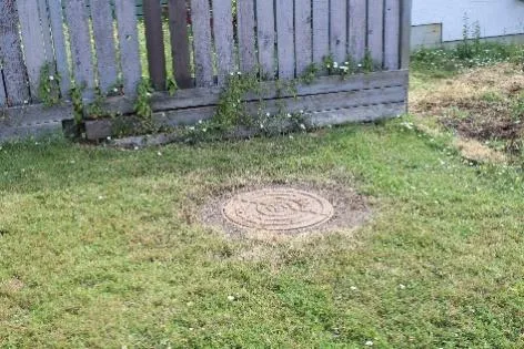 Unburied sewer manhole at 10 Carly Lane requiring work