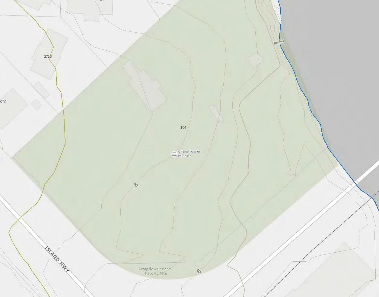 Map titled "PRE-DEVELOPMENT CONTOURS" showing the property layout, contour lines (1m intervals), and the location of Craigflower Manor. The property is bounded by Island Hwy to the south and Admirals Road to the east.