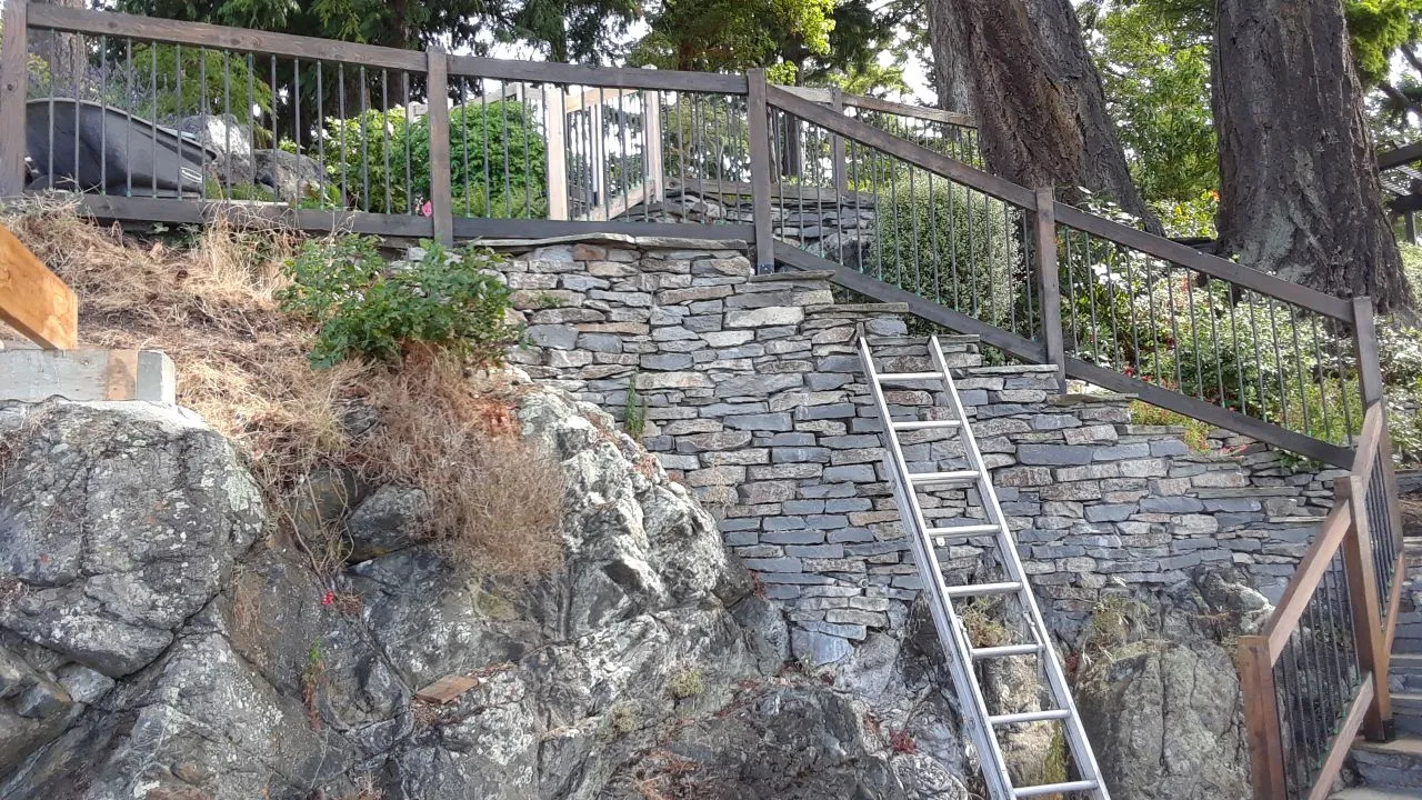 Photo 2. Photo looking east at the rock wall and bedrock adjacent to the dock. The storage shed roof will cover this area (open area underneath)