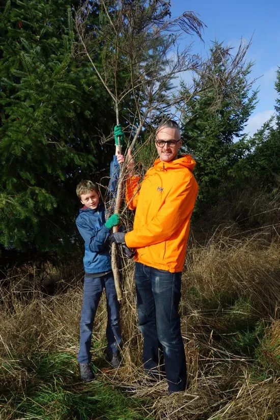 An adult and youth volunteer planting a tree together