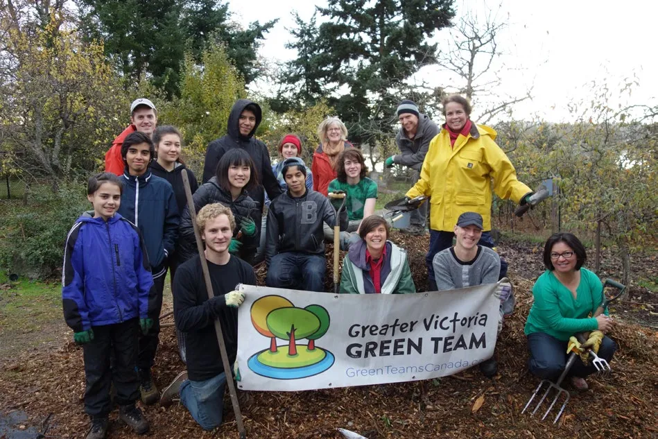 Group photo of volunteers at Portage Park holding a Greater Victoria Green Team banner