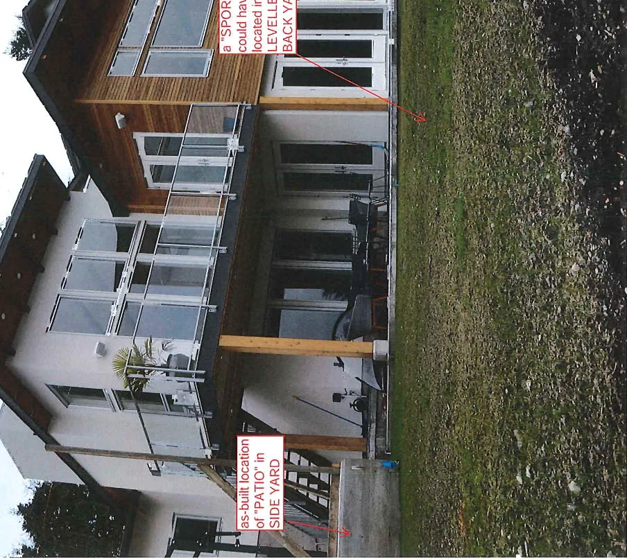 Photo of the back of a modern house with a lawn, annotated showing the 'as-built location of "PATIO" in SIDE YARD' and where a "SPORT COURT" could have been located in the 'LEVELLED BACK YARD'