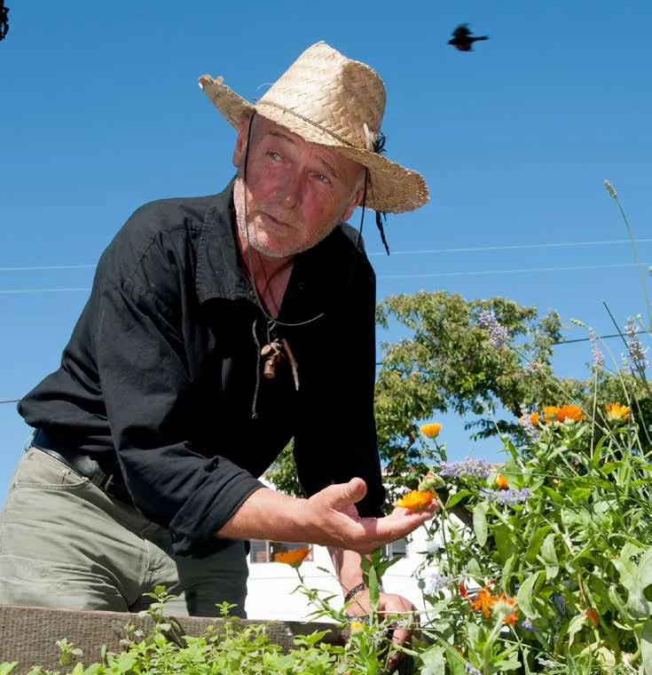 A man in a straw hat working in a garden