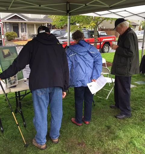 Volunteer B. Stavdal (at right) chats with visitors to the Archives table at the Chilco Trails opening event