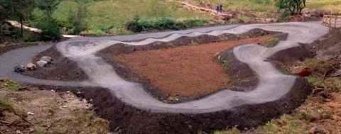 aerial photo of a paved pump track with a central dirt area