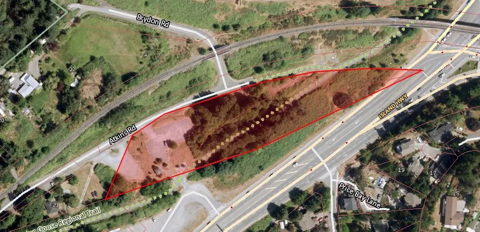 Aerial photograph showing a red polygon outlining a strip of land between Atkins Road and the Island Highway, used for the Galloping Goose Regional Trail
