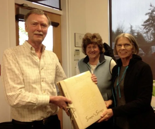 Archives Volunteers accepting a scrapbook donation from David Welham