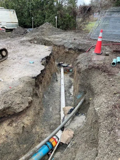Wider view of Packers PS sewer forcemain excavation area with safety cones