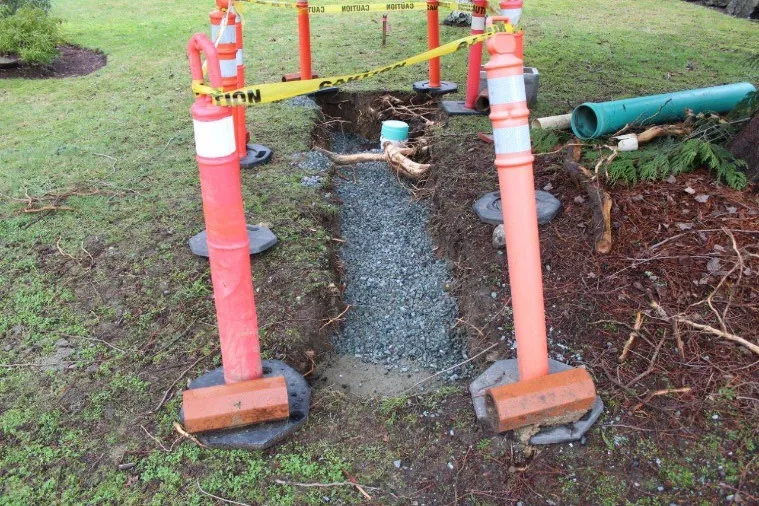 Completed drain service repair at 290 View Royal Avenue with new gravel and safety markers