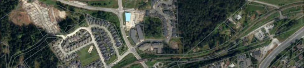Top-right segment of an aerial context map showing forested area and highway infrastructure