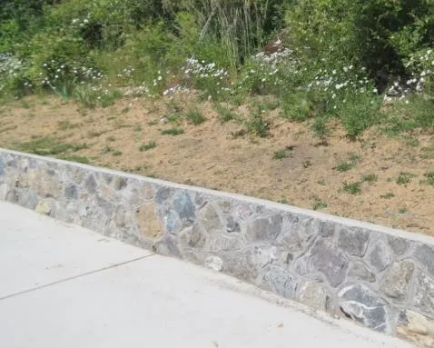 Green space area on Lund Road protected by a rock wall