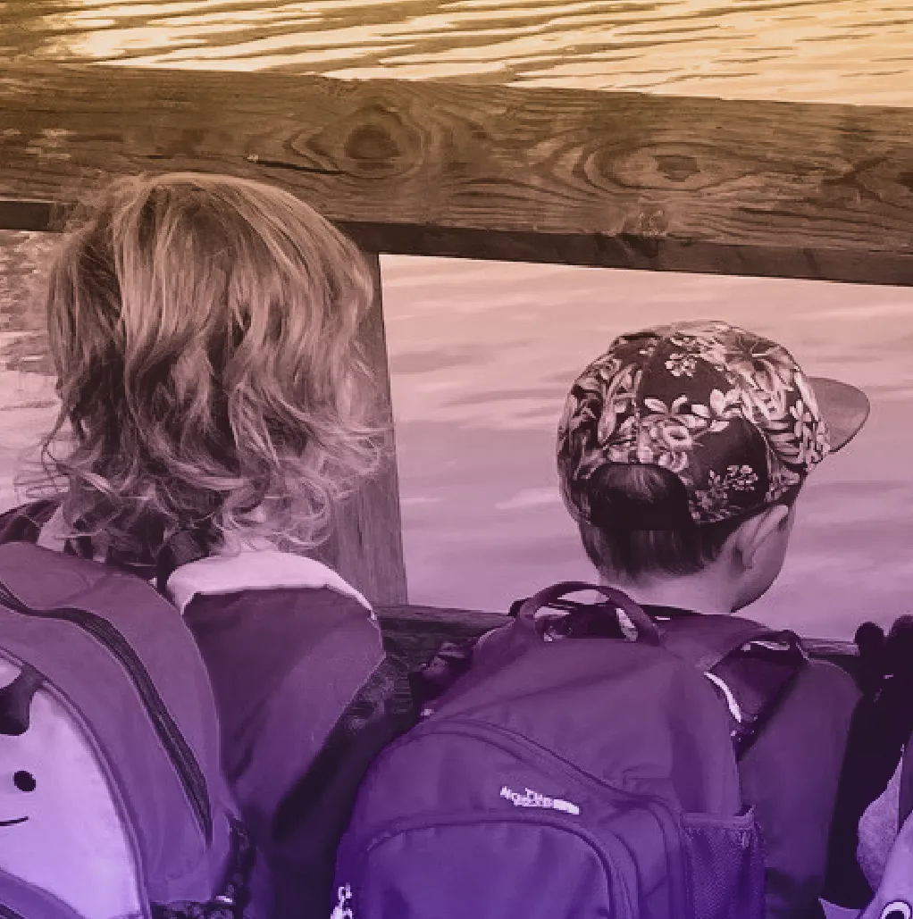 Close-up of two children looking over a wooden railing