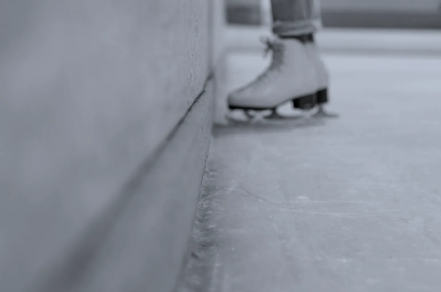 Close-up of an ice skate blade on the surface of an ice rink