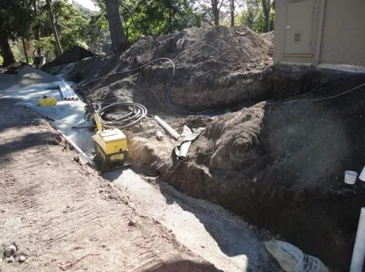 Service trench excavation adjacent to the corner of a building