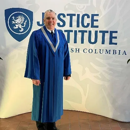 Captain Mollin in graduation robes at the Justice Institute of British Columbia