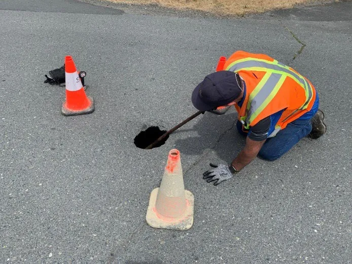 Worker assessing the small sinkhole on Atkins Road