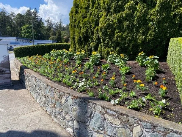 Flower beds along a stone wall at George’s Corner Park