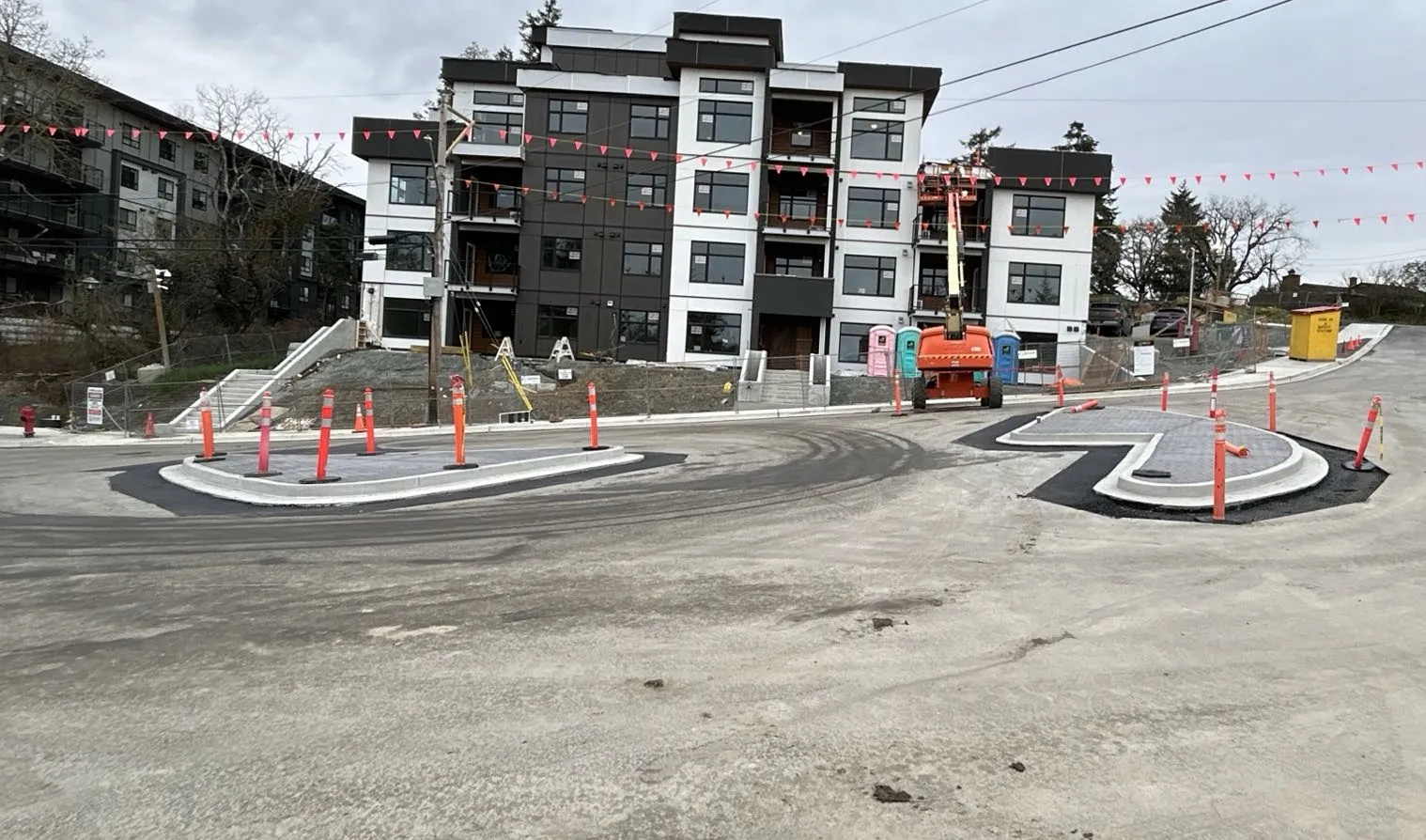 Photo of a new multi-unit residential building with a completed road and roundabout in front