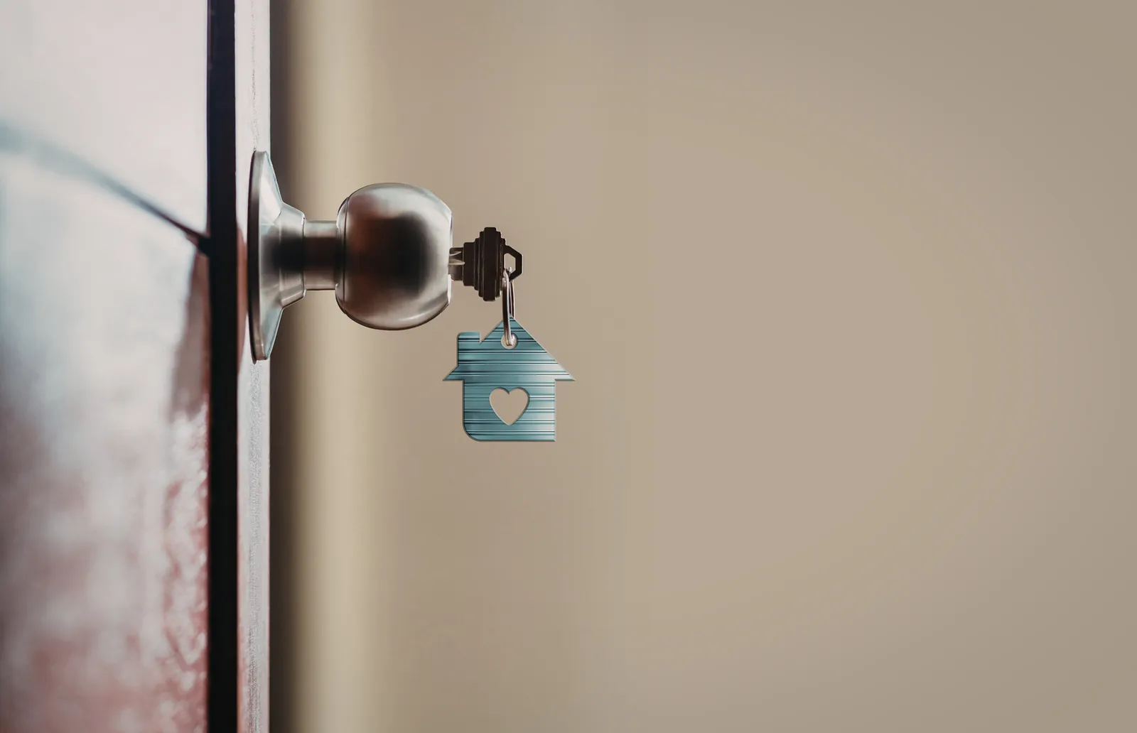 Door handle with a key and house-shaped keychain
