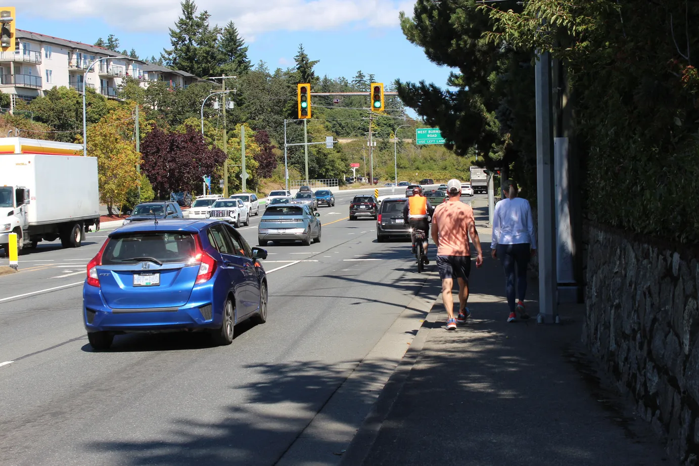 Busy road with cars and pedestrians on a sidewalk