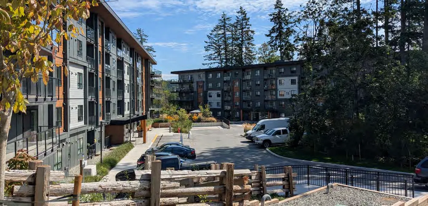 Modern multi-story residential apartment building with balconies and landscaping