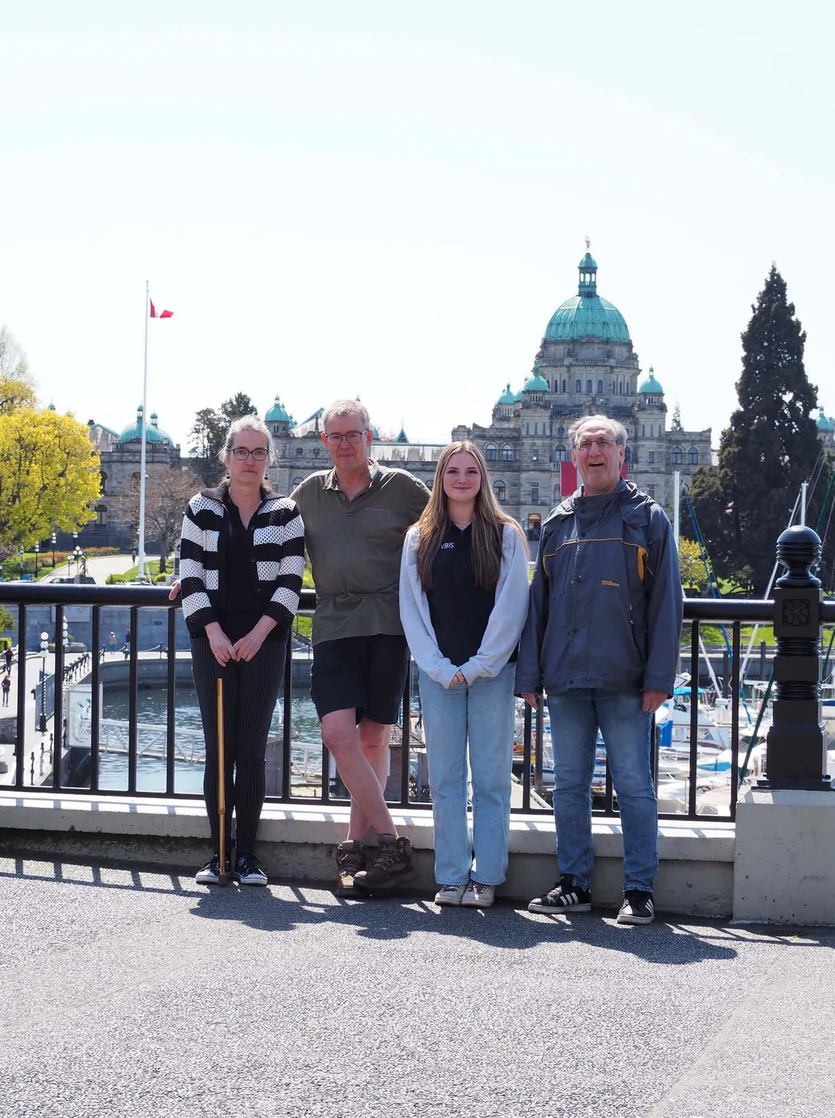 Four people standing in front of the BC Parliament Buildings