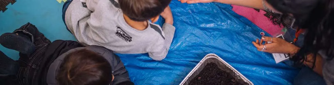 Children and an educator looking at soil samples