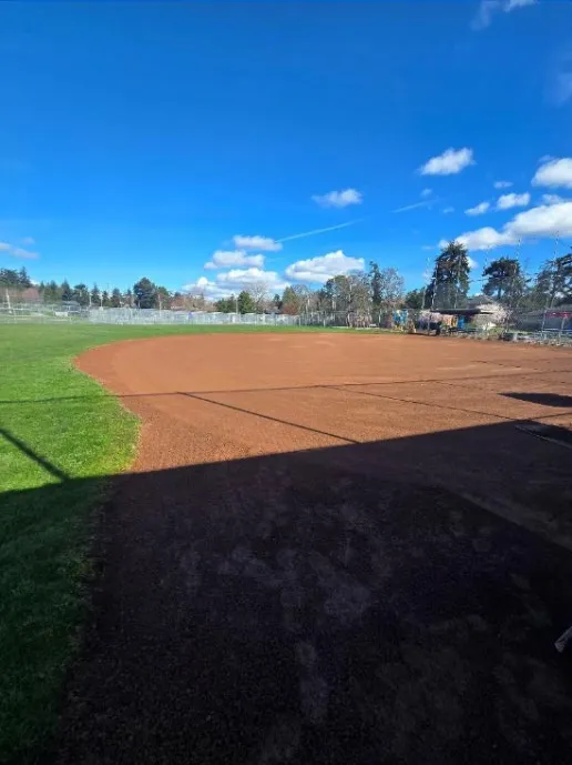 View of a baseball field with freshly prepared dirt infield and green outfield