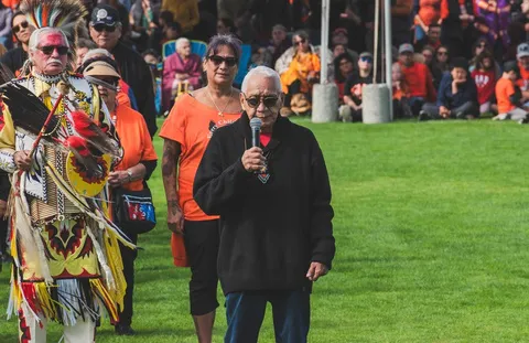 An Elder speaking into a microphone in front of a crowd