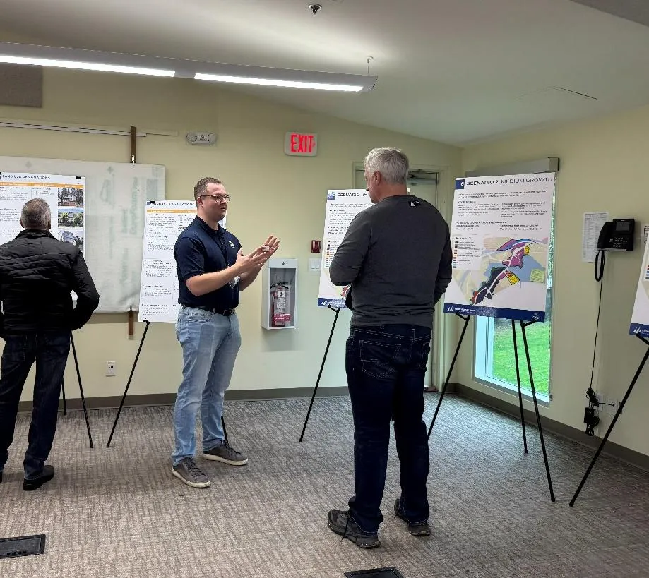 Staff member presenting OCP information to residents at an open house.
