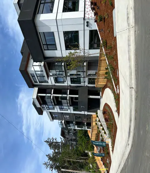 Modern four-story apartment building with balconies.
