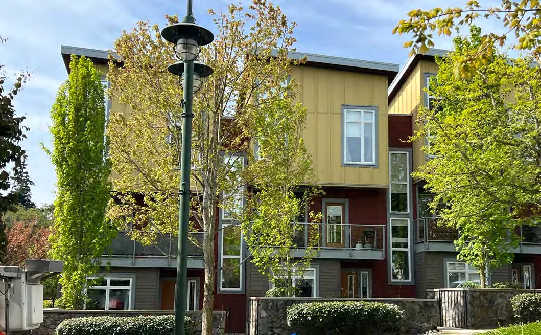 Multi-story residential development with yellow and grey siding.